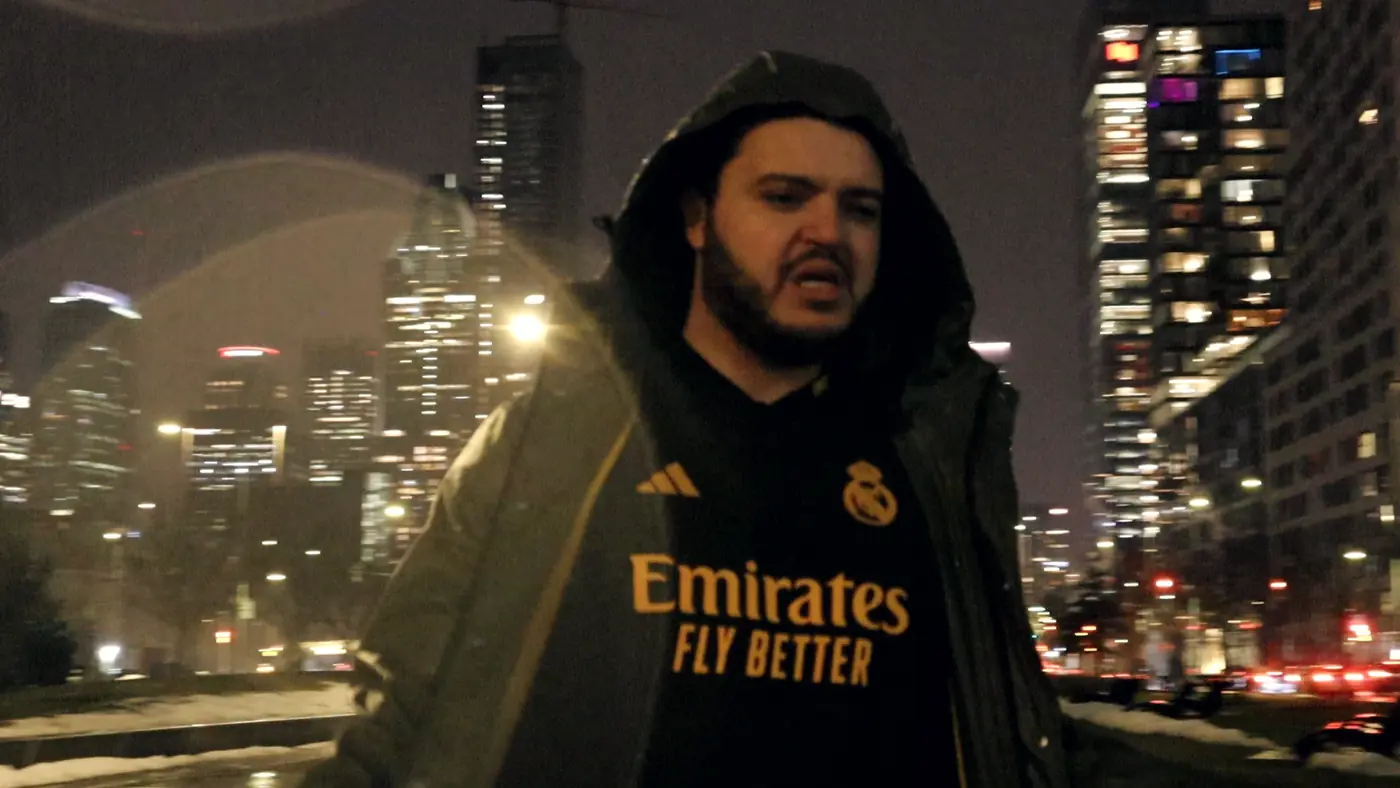 C4PO rapping in the rain, downtown towers behind him