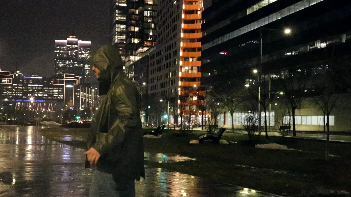 C4PO in a rain jacket on a wet path at night