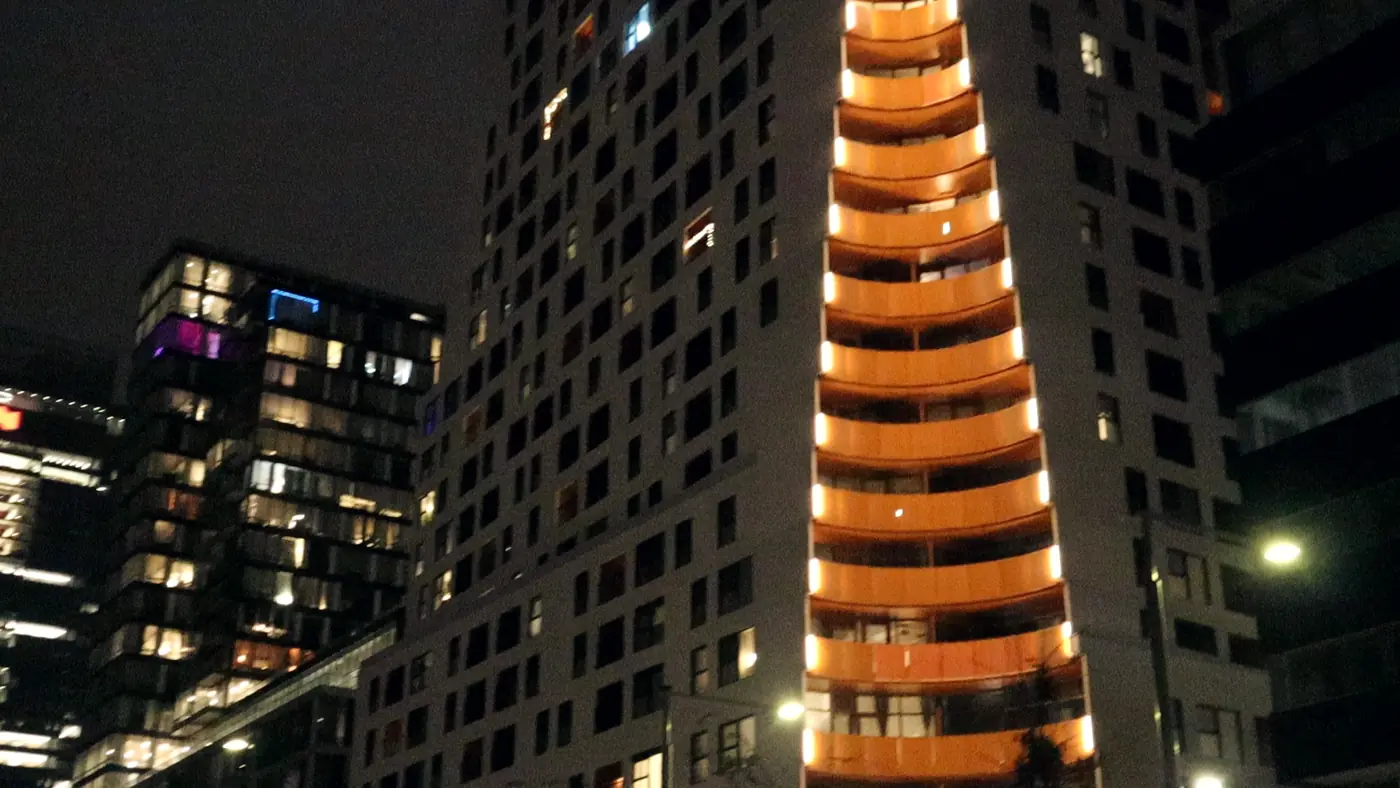 A tower lit in orange at night